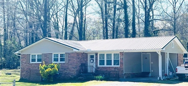 ranch-style house featuring a front yard, an attached carport, aphalt driveway, and brick siding