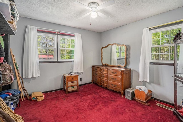 carpeted bedroom with a textured ceiling, visible vents, and ceiling fan