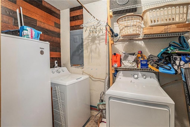 washroom with electric panel, laundry area, and washing machine and dryer