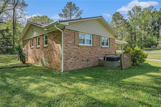 view of side of property featuring a yard and brick siding
