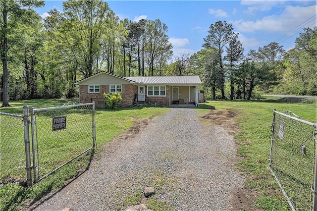 ranch-style home with a gate, fence, a front lawn, and driveway