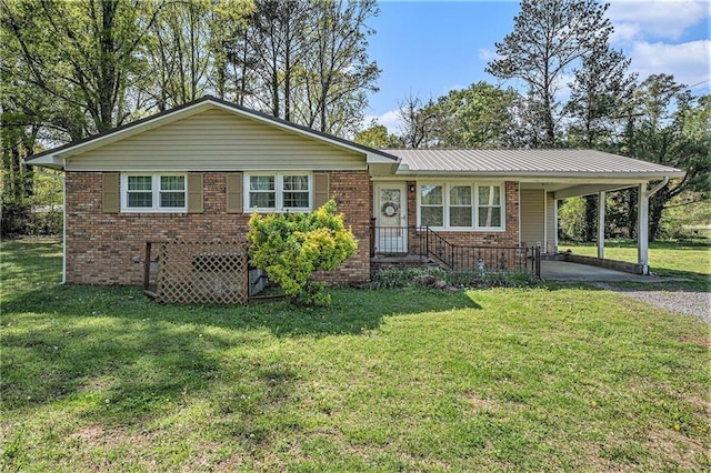 ranch-style home featuring a front yard, gravel driveway, and brick siding