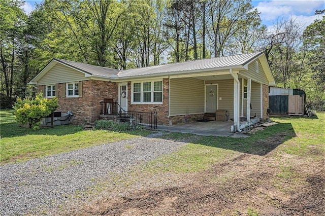 single story home with an attached carport, brick siding, driveway, and a front yard