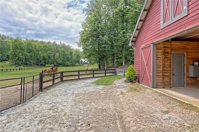 view of yard featuring a rural view and an outbuilding