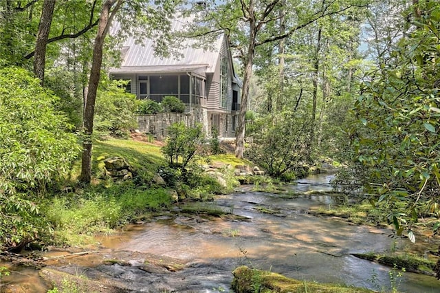 view of side of home featuring a water view and a sunroom