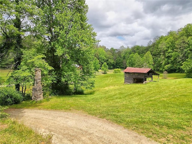 surrounding community featuring a lawn and an outbuilding