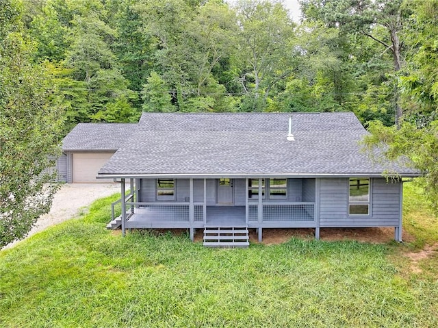 rear view of property featuring a yard, a porch, and a garage