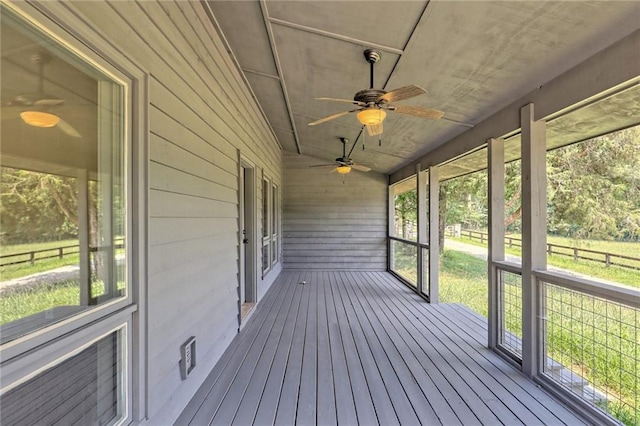 unfurnished sunroom with ceiling fan