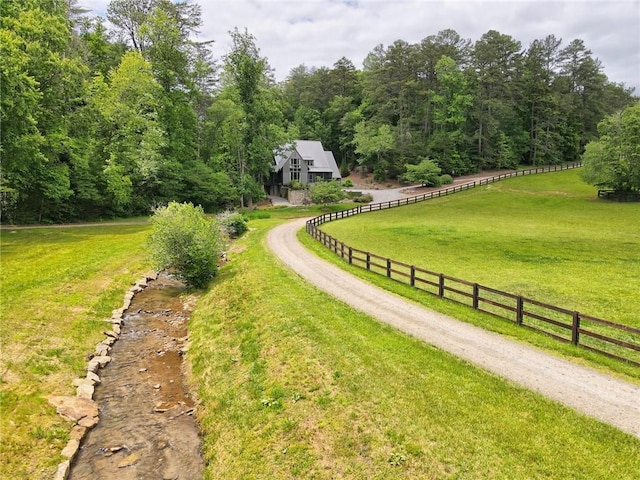 view of property's community featuring a lawn and a rural view