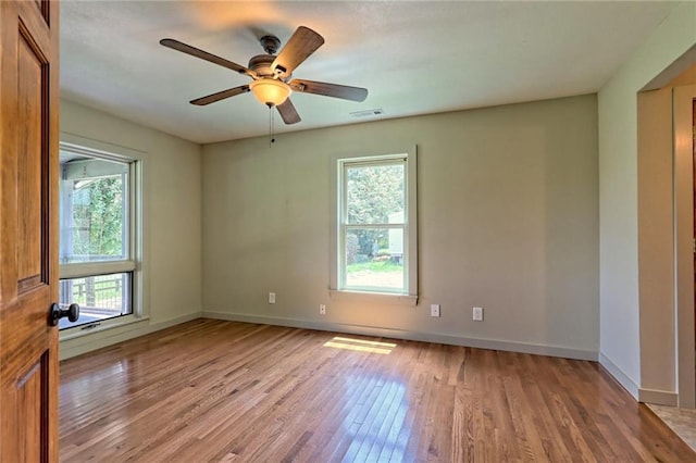 unfurnished room featuring ceiling fan, light wood-type flooring, and a wealth of natural light