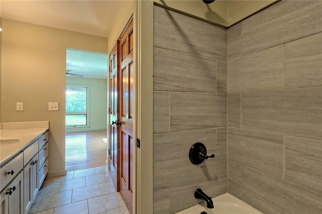 bathroom with tile patterned flooring, vanity, and tiled shower / bath