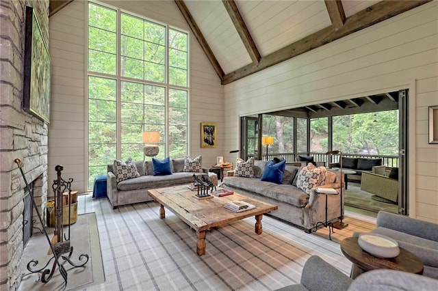 sunroom / solarium with vaulted ceiling with beams and a stone fireplace