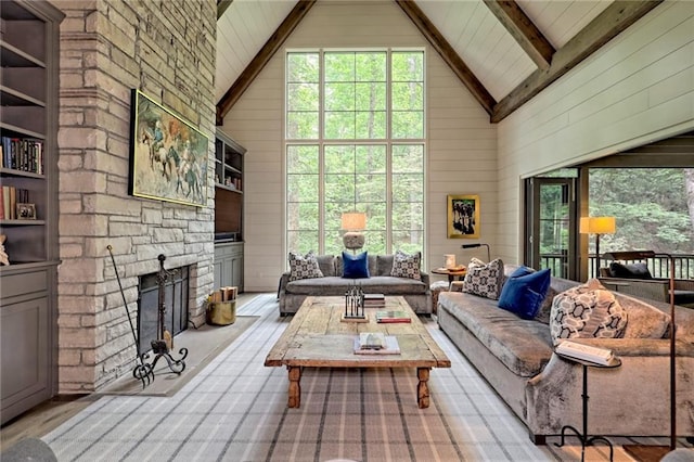 living room with wooden walls, a fireplace, and high vaulted ceiling