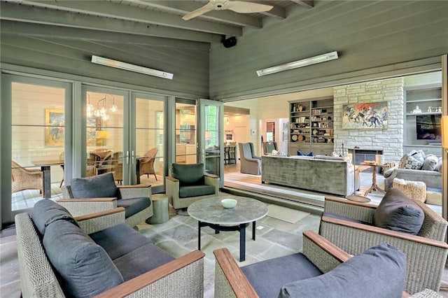 living room featuring beam ceiling, ceiling fan, french doors, built in features, and a fireplace