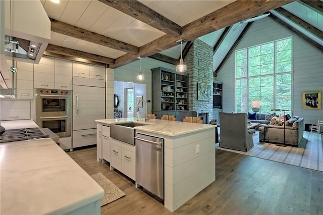 kitchen featuring sink, hardwood / wood-style flooring, an island with sink, white cabinetry, and stainless steel appliances