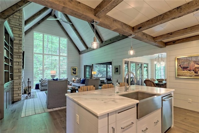 kitchen featuring sink, dark hardwood / wood-style flooring, pendant lighting, a center island with sink, and white cabinets