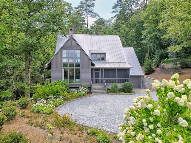 rear view of house with a garage and a sunroom