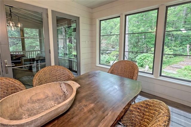 dining area with lofted ceiling and wooden walls