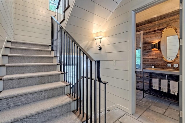 stairs with wood walls and vaulted ceiling