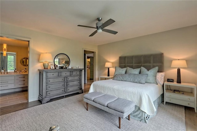 bedroom featuring connected bathroom, ceiling fan, and dark wood-type flooring