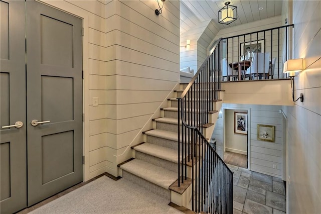 staircase featuring wood walls