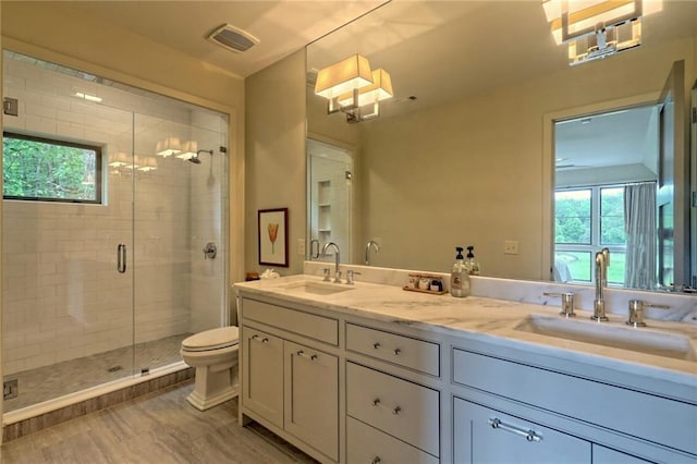 bathroom featuring vanity, toilet, wood-type flooring, and a shower with shower door