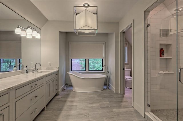 full bathroom featuring shower with separate bathtub, vanity, and toilet