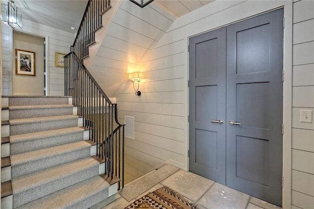 staircase featuring wood walls and vaulted ceiling