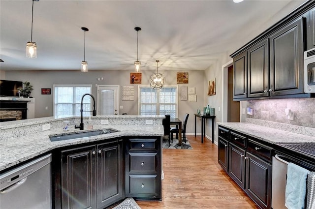 kitchen featuring appliances with stainless steel finishes, decorative light fixtures, a sink, and decorative backsplash