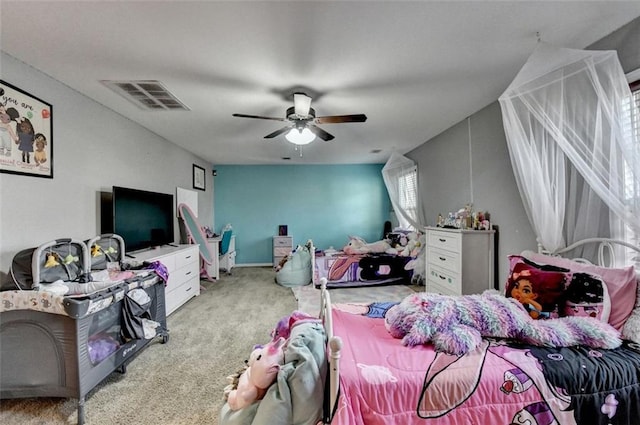 bedroom featuring a ceiling fan, visible vents, and light carpet