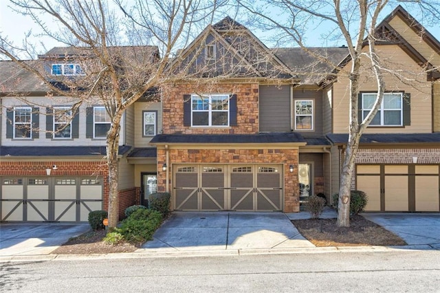 multi unit property with stone siding, an attached garage, and concrete driveway