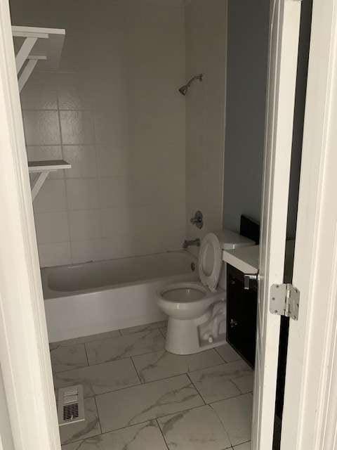 168 Harmony Grove Rd, Lilburn, GA 30047 - full bathroom featuring marble look tile flooring, toilet, bathing tub / shower combination, and vanity