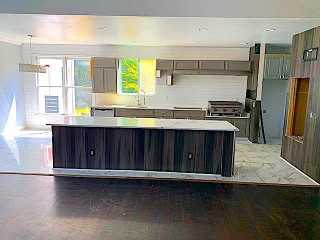 168 Harmony Grove Rd, Lilburn, GA 30047 - kitchen with a sink, light countertops, gray cabinetry, and dishwasher