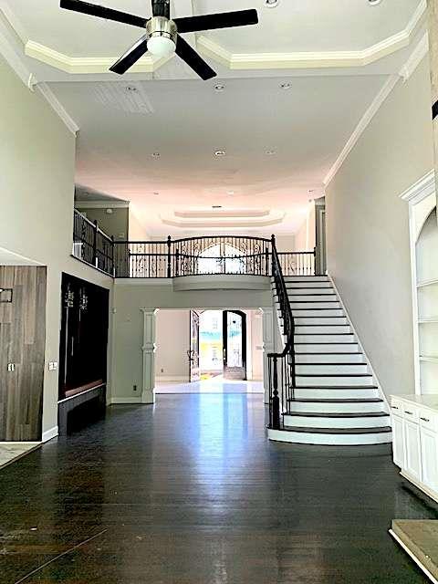 168 Harmony Grove Rd, Lilburn, GA 30047 - stairs with a ceiling fan, crown molding, a towering ceiling, and wood finished floors