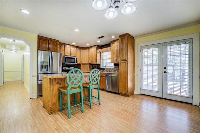 1240 H D Atha Rd, Monroe, GA 30655 - kitchen with french doors, stainless steel appliances, light wood finished floors, ornamental molding, and visible vents