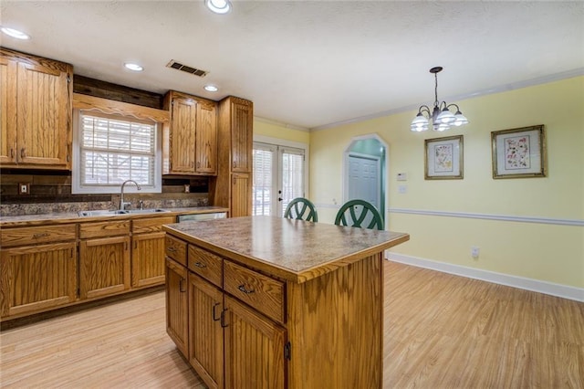 1240 H D Atha Rd, Monroe, GA 30655 - kitchen featuring brown cabinetry, visible vents, light wood finished floors, and a sink