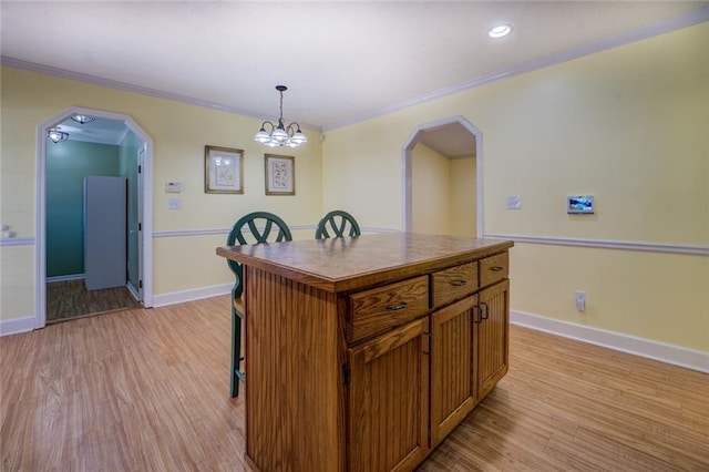 1240 H D Atha Rd, Monroe, GA 30655 - kitchen with a kitchen bar, arched walkways, crown molding, and light wood-type flooring