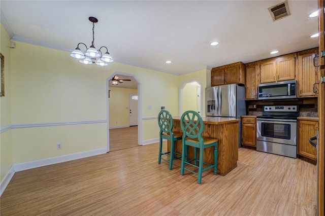 1240 H D Atha Rd, Monroe, GA 30655 - kitchen with visible vents, a kitchen bar, appliances with stainless steel finishes, a kitchen island, and ornamental molding