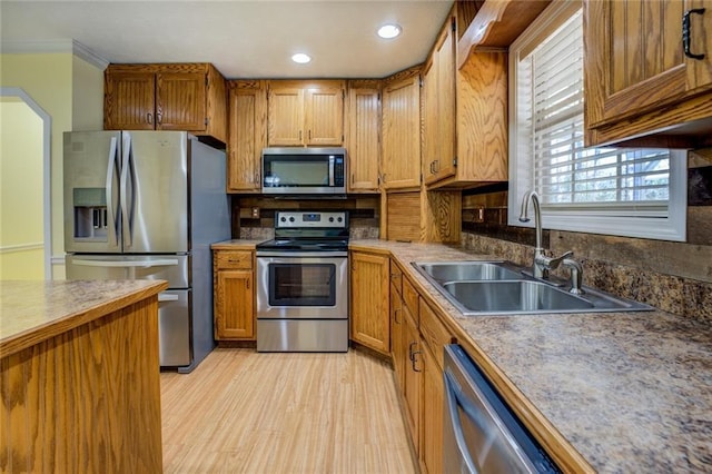 1240 H D Atha Rd, Monroe, GA 30655 - kitchen featuring stainless steel appliances, a sink, light wood-type flooring, brown cabinets, and crown molding