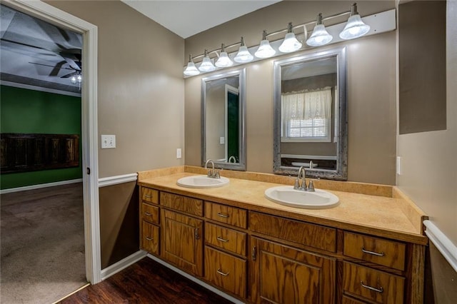 1240 H D Atha Rd, Monroe, GA 30655 - bathroom featuring double vanity, a ceiling fan, wood finished floors, and a sink