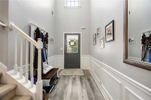 entrance foyer with hardwood / wood-style floors and a towering ceiling