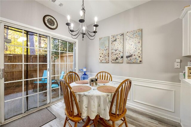 dining area featuring light hardwood / wood-style floors and an inviting chandelier