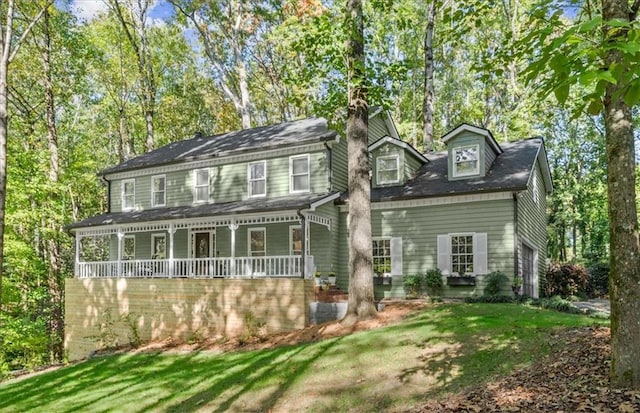 view of front facade featuring covered porch and a front yard