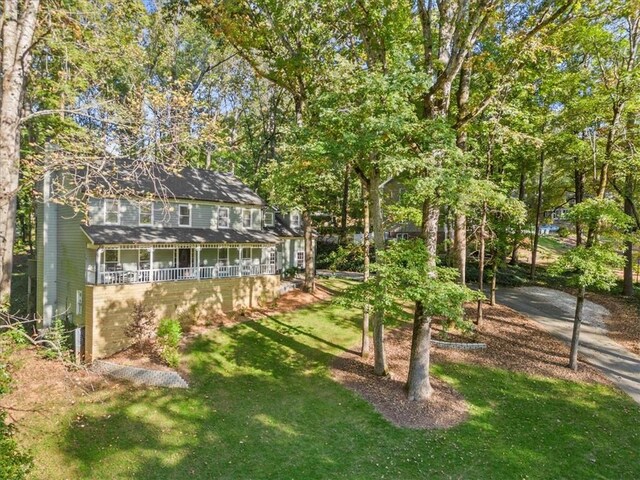 rear view of property with a patio, a sunroom, and an outdoor fire pit