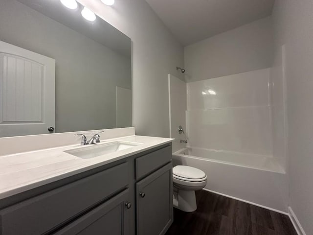 full bath with toilet, shower / bath combination, wood finished floors, and vanity