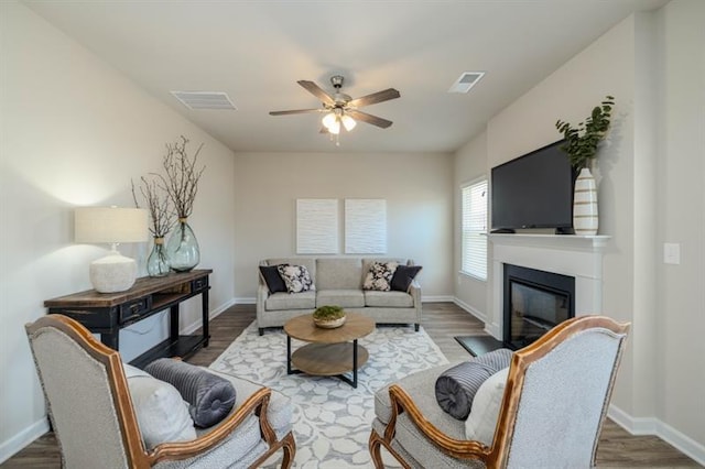 living room featuring ceiling fan and dark hardwood / wood-style flooring