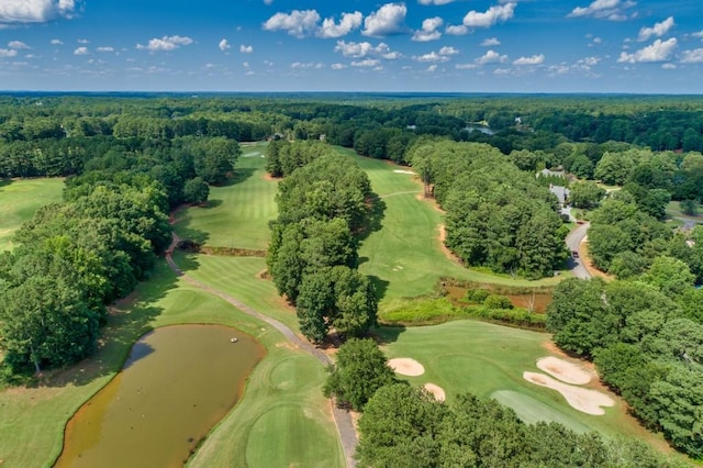 drone / aerial view with golf course view and a wooded view