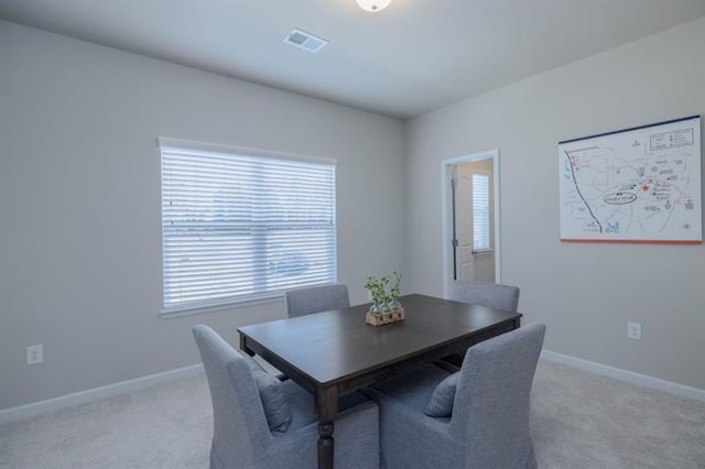 carpeted dining area with plenty of natural light