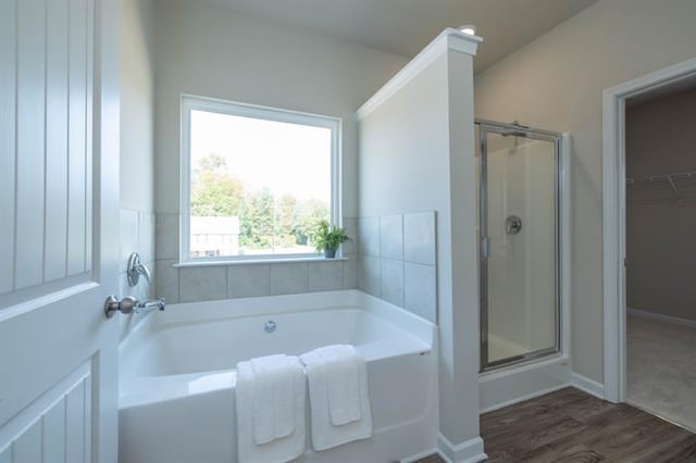 bathroom featuring hardwood / wood-style flooring and plus walk in shower