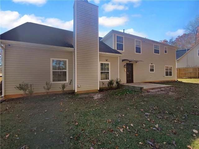 rear view of property featuring a lawn and a patio